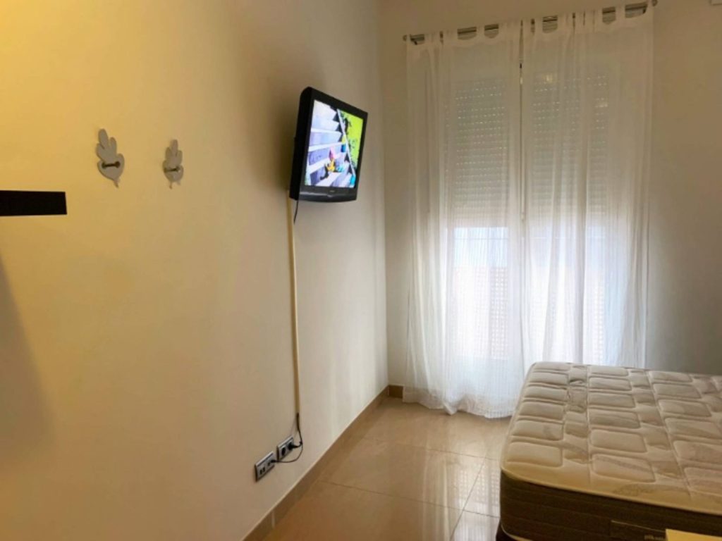 Habitación con televisor y cama